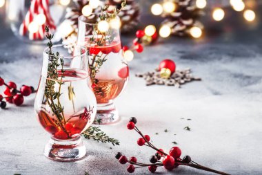 Kırmızı çilek, likör, cin, kekik ve Noel veya Yeni Yıl için votka ile Kış alkollü kokteyl. Tatil masası ayarı