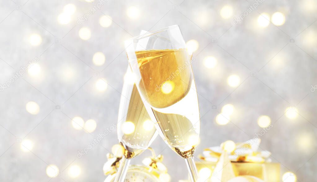 Two champagne glasses and christmas decoration over gray golden bokeh background. Happy New Year Celebration. Selective focus and small depth of field