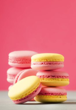 Yumuşak pembe arka plan masasında pembe badem kurabiyeleri, metin için yer, minimalizm tarzı