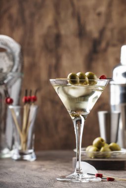 Klasik Martini votkası, kuru vermut, votka ve yeşil zeytin, bar aletleri, klasik ahşap bar tezgahı, seçici odaklı.