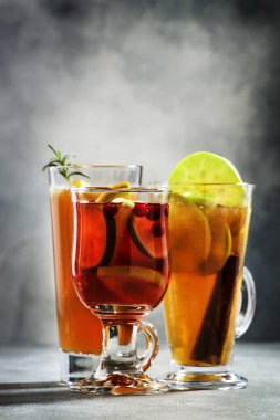 Sonbahar ya da kış aylarında içilen sıcak kokteyller - sıcak şarap, glogg, grog, eggnog, sıcak zencefilli gazoz, sıcak tereyağlı rom, punç, gri arka planda sıcak elma şarabı, kopyalama alanı