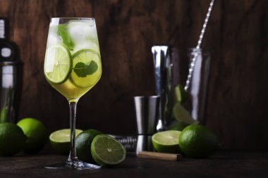 Limonlu mojito kokteyli ve ahşap arka planda şarap bardağında nane şekeri. Boşluğu kopyala