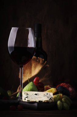 Kırmızı şarap cam ve meze, peynir, salam, incir, üzüm, vintage ahşap masa arka plan, seçici odak, kopya alanı