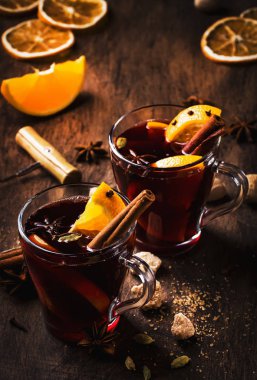 Baharatlı sıcak kırmızı şarap ve ahşap kırsal masada meyveler. Geleneksel Noel içeceği, boşluğu kopyala