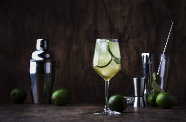 Limonlu mojito kokteyli ve ahşap arka planda şarap bardağında nane şekeri. Boşluğu kopyala