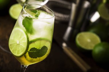 Limonlu mojito kokteyli ve ahşap arka planda şarap bardağında nane şekeri. Boşluğu kopyala