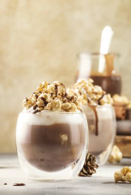 Krem şantili, patlamış mısır ve bej arka planda gözlüklü karamel kaplı soğuk çikolata tatlısı. Mesaj için yer.