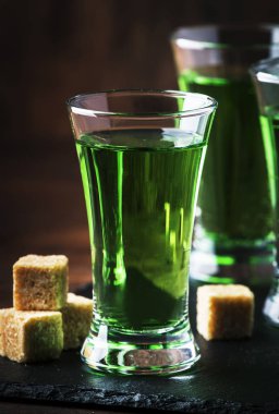 Absinthe-güçlü alkollü içecek, eski ahşap masada gözlük yeşil acı pelin tentür, metin için yer