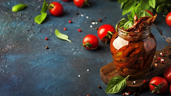 イタリアの日青のキッチンテーブルの上のガラス瓶に緑のバジルとスパイスとオリーブオイルでトマトを乾燥させ スペースをコピー — ストック写真