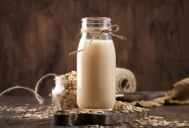Vejetaryen yulaf gevreği sütü, süt içermeyen süt bardakta alternatif süt, ahşap kırsal masa, kopyalama alanı