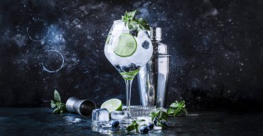Romlu yaban mersinli mojito, yeşil nane, limon ve ezilmiş buz, bar aletleri, mavi bar tezgahı, seçici odak