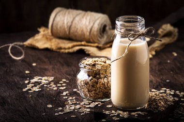 Yulaf gevreği süt, süt ürünü olmayan alternatif bitki cam bazlı içecek, ahşap kırsal mutfak masası, kopyalama alanı