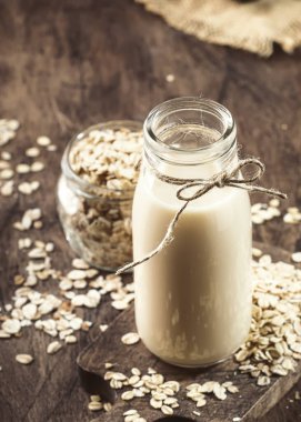 Yulaf gevreği süt, süt ürünü olmayan alternatif bitki cam bazlı içecek, ahşap kırsal mutfak masası, kopyalama alanı