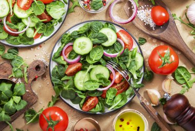 Ispanaklı vegan salatası, vişneli domates, mısır salatası ve kırmızı soğanlı. Sağlıklı gıda konsepti. Bej renkli taş masa arka planı. Üst görünüm