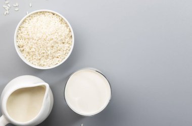 Gri masada pirinç taneli pirinç sütü. Boşluğu kopyala, üst görünüm