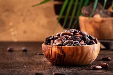 Ahşap arka planda soyulmamış kakao çekirdeği, yakın plan. Boşluğu kopyala