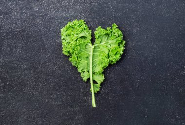 Lahana kabağı. Yeşil sebze yaprakları, siyah arka plan manzarası, sağlıklı beslenme, vejetaryen yiyecekler.