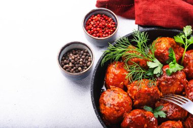 Domates soslu köfteler ve arka planda kızarmış tavada baharatlar. Kopyalama alanı ile Üst Görünüm