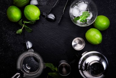 Bar aletleri. Limonlu mojito kokteyli, nane yaprağı ve buz. Soğuk içecek ve içecek hazırlığı. Siyah tablo, kopyalama alanı olan üst görünüm