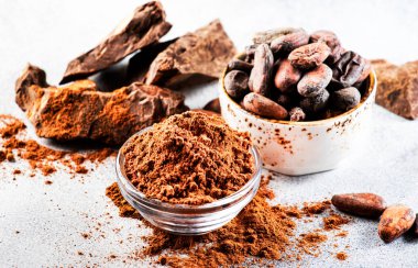 Organik kakao tozu, kakao çekirdeği, gri arka planda rendelenmiş kakao. Boşluğu kopyala