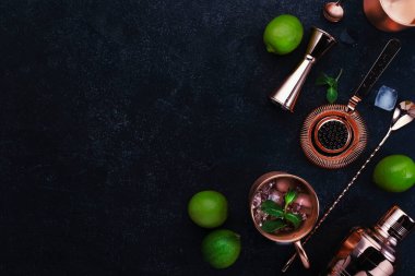 Zencefilli bira, votka, limon ve buzlu Moskova Mule kokteyli. Bakır bar aletleri. Siyah bar tezgahı. Üst Manzara. Boşluğu kopyala