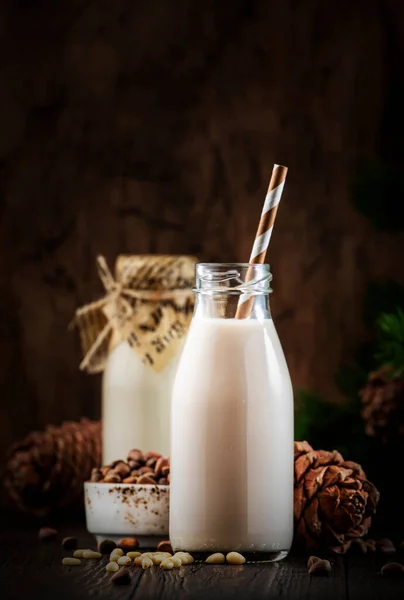 瓶装雪松坚果牛奶 特写镜头 木制桌子背景 非乳制品代用品奶 健康素食和饮料的概念 复制空间 — 图库照片
