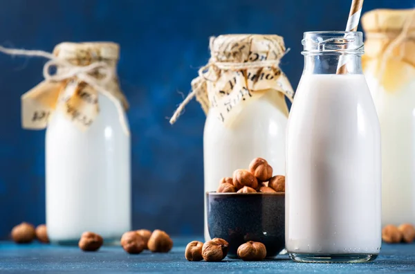 Vegane Haselnussmilch Flaschen Nahaufnahme Blauer Tischhintergrund Milchfreie Alternativmilch Gesundes Vegetarisches — Stockfoto