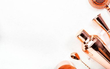 Kokteyl yapmak için bakır bar aletleri ve aksesuarları. Titretici, jigger, süzgeç, kaşık, maşa, muddler. Alkol ve içecek hazırlama konsepti. Beyaz arkaplan, üst görünüm, kopyalama alanı