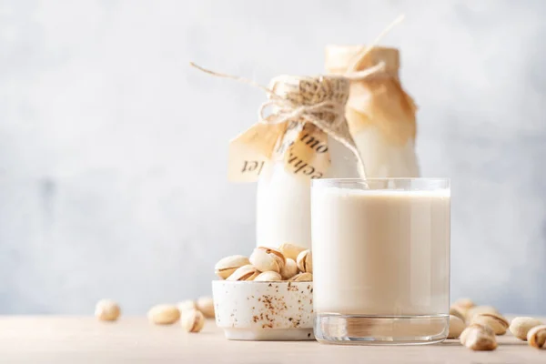 Vegan Pistachio Ořechové Mléko Lahvích Detailní Záběr Béžové Stolní Pozadí — Stock fotografie