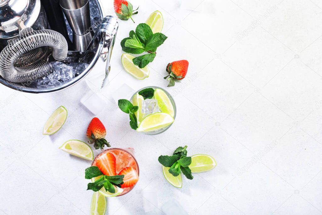 Fresh Mojito cocktail set with lime, mint, strawberry and ice in glass on white background. Summer cold alcoholic non-alcoholic drinks, beverages and cocktails. Bar tools. Copy space. Top view