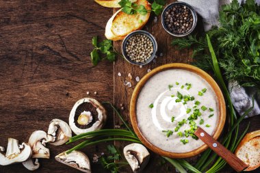 Kırsal ahşap zemin üzerinde kızarmış ekmek ve soğanlı kremalı mantar çorbası.