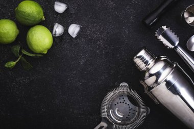 Bar aletleri. Limonlu mojito kokteyli, nane yaprağı ve buz. Soğuk içecek ve içecek hazırlığı. Siyah tablo, kopyalama alanı olan üst görünüm