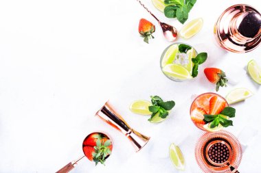 Limon, nane, çilek ve beyaz arka planda buzlu taze Mojito kokteyli. Yaz aylarında alkolsüz içecekler, içecekler ve kokteyller. Bakır bar aletleri. Uzayı kopyala Üst görünüm