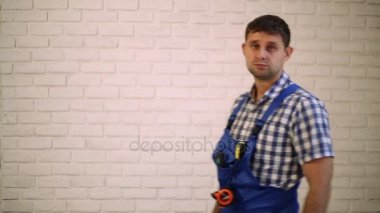 Bir tornavida olan bir adam. İşçi tamirci, Oluşturucusu çalışma türden. Ana güç araçları. Bir tornavida elinde tutan adam. İşçi başparmak gösterilmesini tornavida ile.