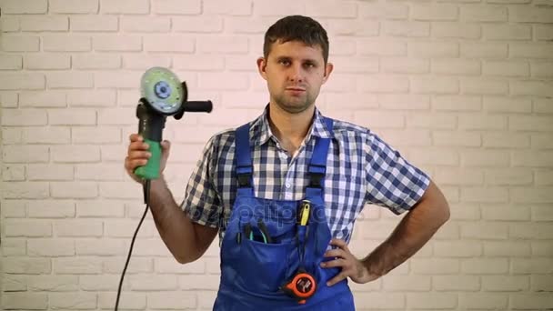 Człowiek z szlifierki kątowej. Mechanik, master professional. Człowiek posiada w jego dłoń narzędzie elektryczne. Pracownik z szlifierki kątowej. — Wideo stockowe