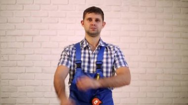 Oluşturucu kollarını göğsünde geçti. Adam, işçi, mühendis, foreman bir arka planda bir tuğla duvar. Adam kollarını göğsünde geçti..