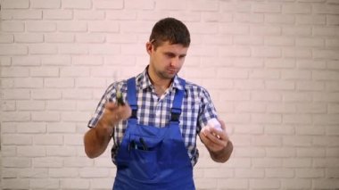 Elektrikçiler, inşaat işçisi bir tornavida ile. Adam bir elektrikli cihaz bir tornavida ile onarır. İşçi, builder, tamirci.