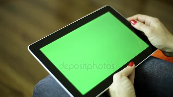 Uma mulher segura um tablet com uma tela verde. Computador tablet com tela verde para o seu conteúdo. Mulher com um comprimido . — Vídeo de Stock