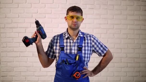 Trabajador de construcción con destornillador. Un hombre sosteniendo un destornillador en su mano. Hombre con herramientas eléctricas . — Vídeo de stock