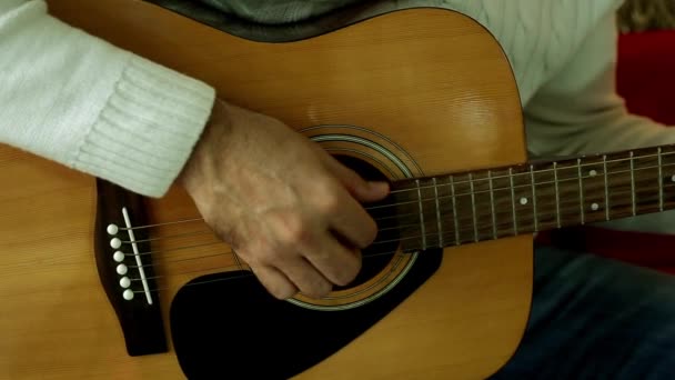 Ο άνθρωπος παίζει κιθάρα close-up. Δάχτυλα, παίζοντας με τις χορδές της κιθάρας. Ένας άνθρωπος με μια ακουστική κιθάρα. — Αρχείο Βίντεο