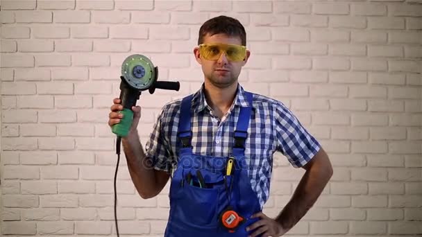 Man with angle grinders. Man makes repairs.  Construction worker holding a angle grinder. — Stock Video