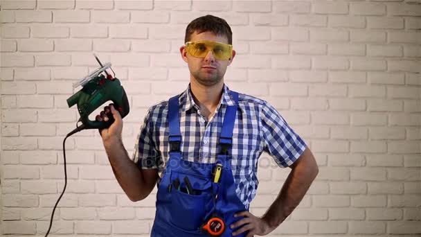 Man with an electric jig saw.  Working with electric jig saw. Construction worker with a power tool. Man makes repairs — Stock Video
