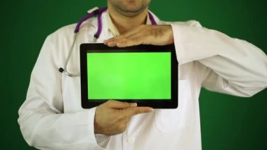 Doktor bir tablet bilgisayar ile. Beyaz önlük erkek doktor. Yeşil bir arka plan üzerine doktor. Modern tıp, cerrah, tedavi, yeni teknolojiler.