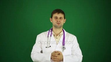 Doktor yeşil arka plan üzerinde nesne üzerinde gösterir. Beyaz önlük erkek doktor. Genç bir dost doktor.