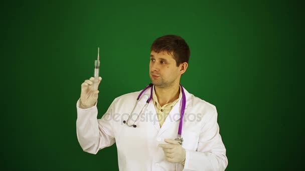 Doktor yeşil bir arka plan üzerinde bir şırınga. Doktor enjekte etmeye hazırlanıyor. Doktor bir şırınga tutuyor.