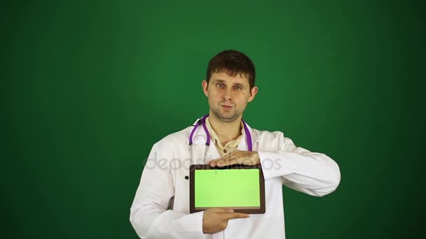Lekarz w białym fartuchu. Lekarz z komputera typu tablet. Lekarz na zielonym tle. Współczesnej medycyny, chirurg, leczenie, nowe technologie. — Wideo stockowe