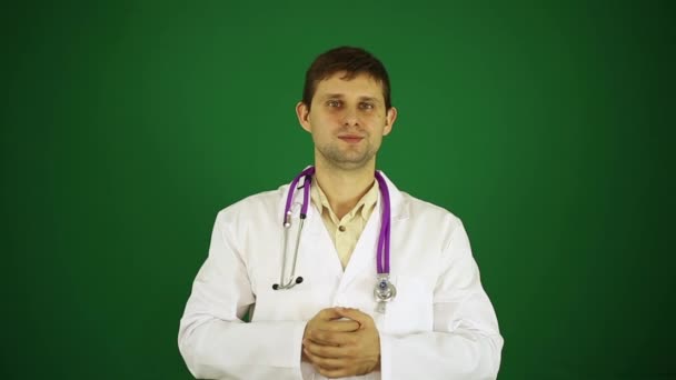 Orvos felbukkan remek. Pozitív orvos egy zöld háttér, hromakey. Fiatal orvos, terapeuta, remek műsorok. — Stock videók