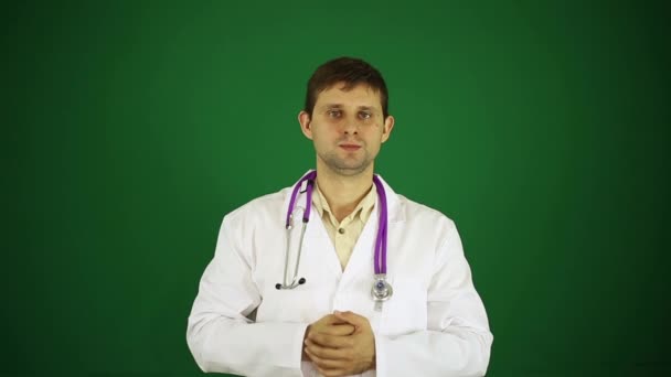 Doctor ukazuje palec. Pozitivní doktor na zeleném pozadí. Lékař, usmívá se a ukazuje palec nahoru. — Stock video