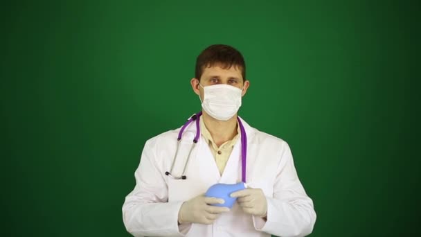 Orvos-val a beöntés. A zöld háttéren fehér laborköpeny orvos. Orvos a maszkban tart egy beöntés. — Stock videók