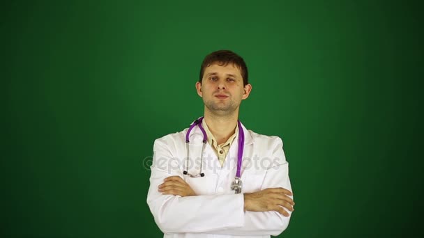 Serious doctor on a green background. — Stock Video